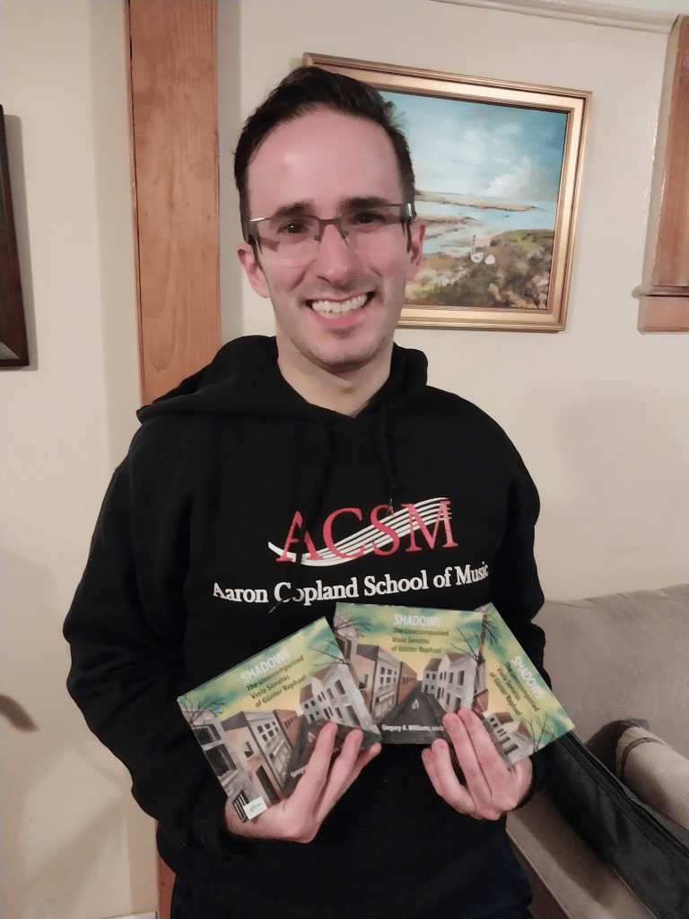Gregory Williams holding several copies of SHADOWS; his debut album
